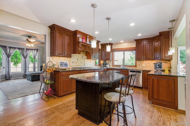 18704 Gary Ln, Livonia, MI 48152 - kitchen featuring stainless steel appliances, plenty of natural light, a kitchen island, dark stone counters, and recessed lighting