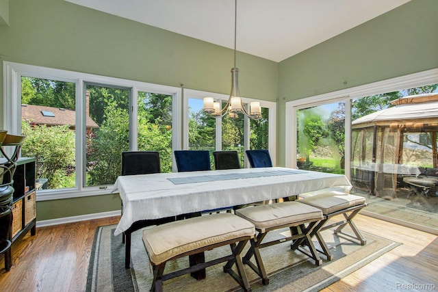 18704 Gary Ln, Livonia, MI 48152 - dining space featuring a chandelier, plenty of natural light, lofted ceiling, and wood finished floors