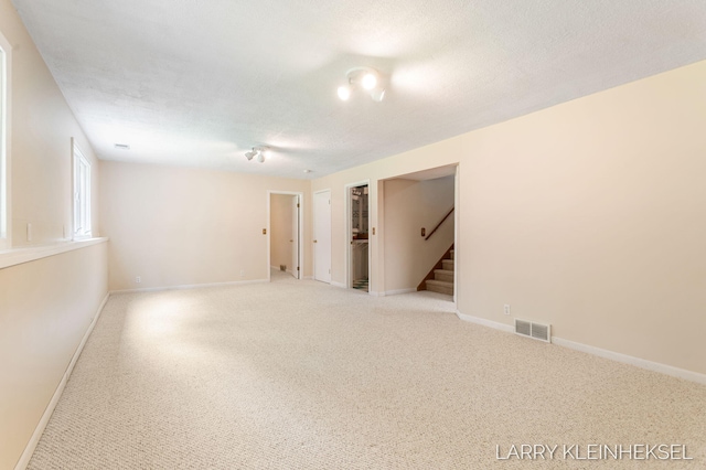 569 Appletree Dr, Holland, MI 49423 - spare room with stairs, light colored carpet, baseboards, and a textured ceiling