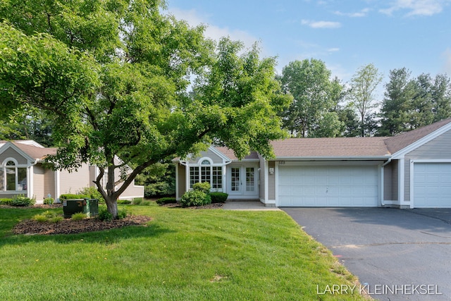 569 Appletree Dr, Holland, MI 49423 - view of front facade with asphalt driveway, a front yard, an attached garage, and french doors