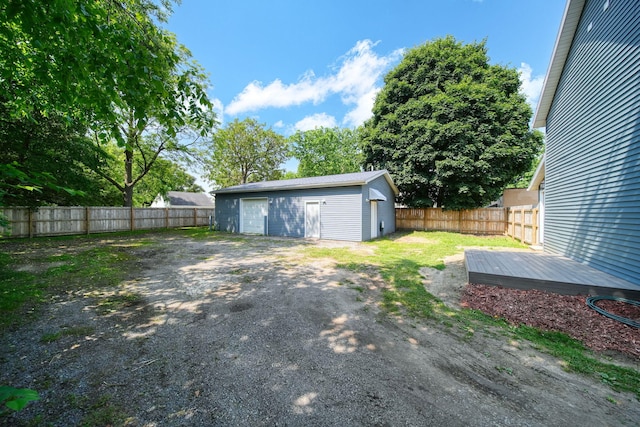 911 E Ganson St, Jackson, MI 49201 - fenced backyard featuring a garage, an outdoor structure, and a wooden deck