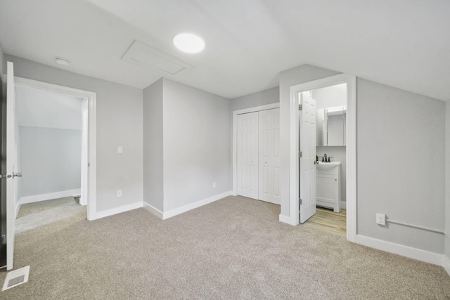 911 E Ganson St, Jackson, MI 49201 - unfurnished bedroom featuring carpet, a sink, baseboards, a closet, and vaulted ceiling