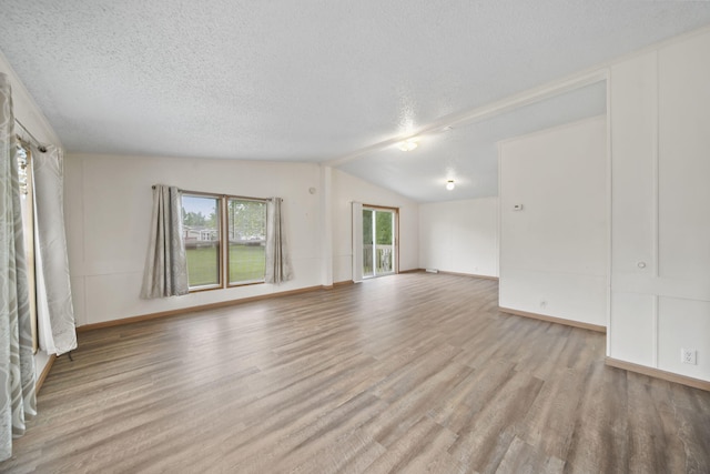 948 Savannah River Dr, Adrian, MI 49221 - unfurnished living room with a textured ceiling, wood finished floors, vaulted ceiling, and baseboards