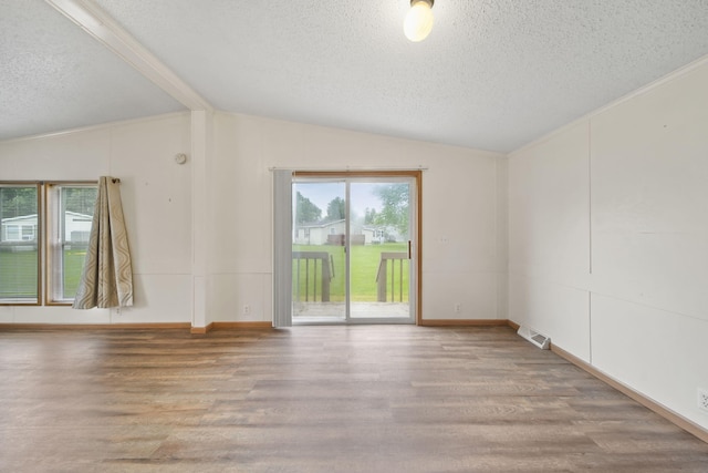 948 Savannah River Dr, Adrian, MI 49221 - empty room with vaulted ceiling, a textured ceiling, and wood finished floors