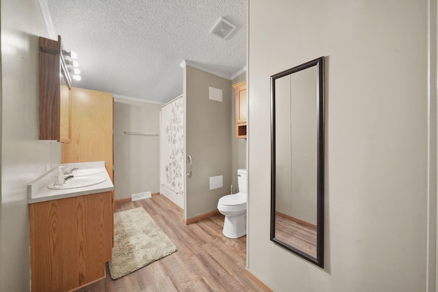 948 Savannah River Dr, Adrian, MI 49221 - full bathroom featuring toilet, wood finished floors, vanity, a textured ceiling, and crown molding