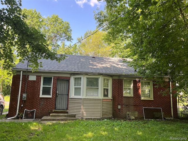 4150 Woodhall St, Detroit, MI 48224 - bungalow-style house featuring brick siding, a shingled roof, and a front yard