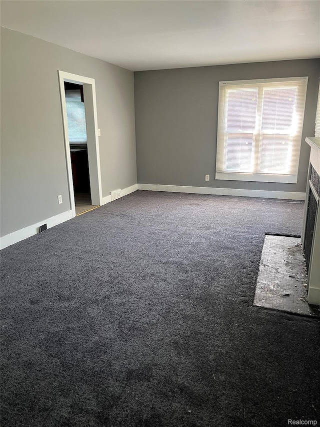4150 Woodhall St, Detroit, MI 48224 - carpeted empty room with a fireplace and baseboards