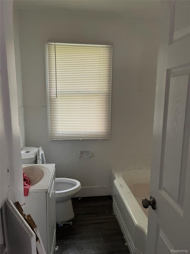 4150 Woodhall St, Detroit, MI 48224 - bathroom featuring toilet, wood finished floors, vanity, a bathtub, and tile walls