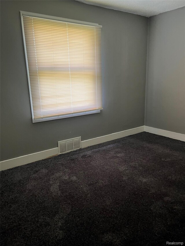 4150 Woodhall St, Detroit, MI 48224 - spare room featuring dark carpet and baseboards