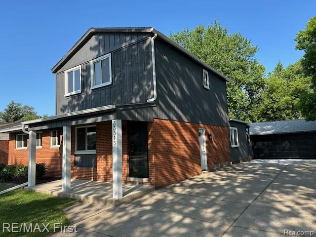 33315 Vista Way, Fraser, MI 48026 - view of front of property featuring brick siding, covered porch, and a garage