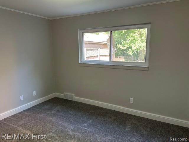 33315 Vista Way, Fraser, MI 48026 - empty room with dark colored carpet, baseboards, and ornamental molding