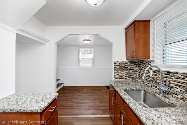 22005 Rausch Ave, Eastpointe, MI 48021 - kitchen featuring a sink, wood finished floors, decorative backsplash, light stone counters, and baseboards
