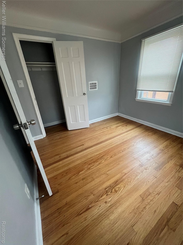 22005 Rausch Ave, Eastpointe, MI 48021 - unfurnished bedroom featuring light wood-type flooring, baseboards, a closet, and ornamental molding
