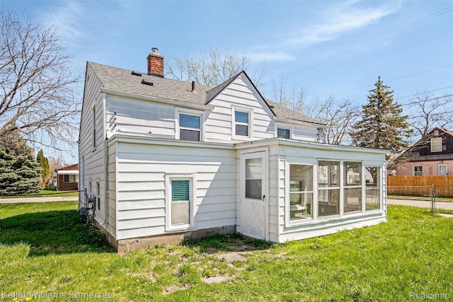 22005 Rausch Ave, Eastpointe, MI 48021 - back of property with a sunroom, a chimney, and roof with shingles
