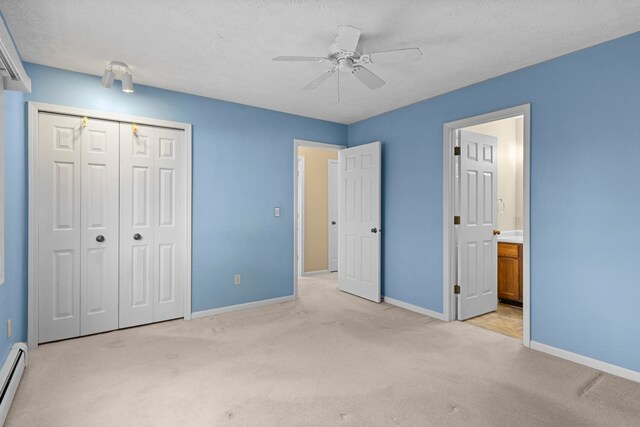 515 Georgetown Dr, Traverse City, MI 49684 - unfurnished bedroom with light carpet, baseboards, a closet, a baseboard heating unit, and connected bathroom