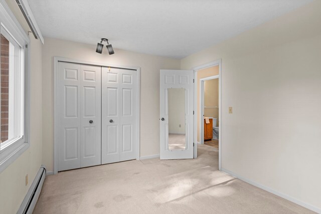 515 Georgetown Dr, Traverse City, MI 49684 - unfurnished bedroom featuring a baseboard heating unit, carpet floors, baseboards, and a closet