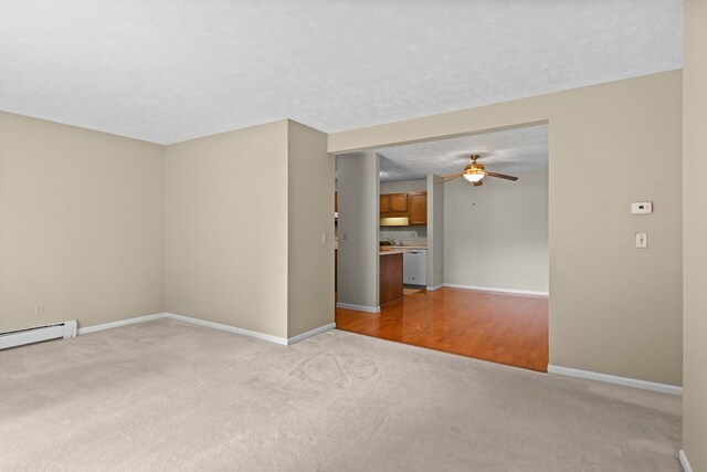 515 Georgetown Dr, Traverse City, MI 49684 - spare room with light carpet, a ceiling fan, baseboards, and a baseboard heating unit