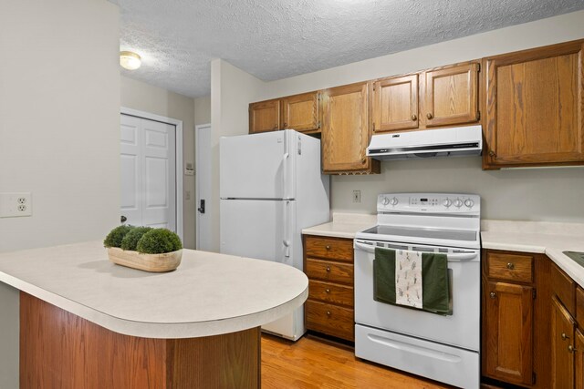 515 Georgetown Dr, Traverse City, MI 49684 - kitchen featuring white appliances, extractor fan, light countertops, brown cabinetry, and a textured ceiling