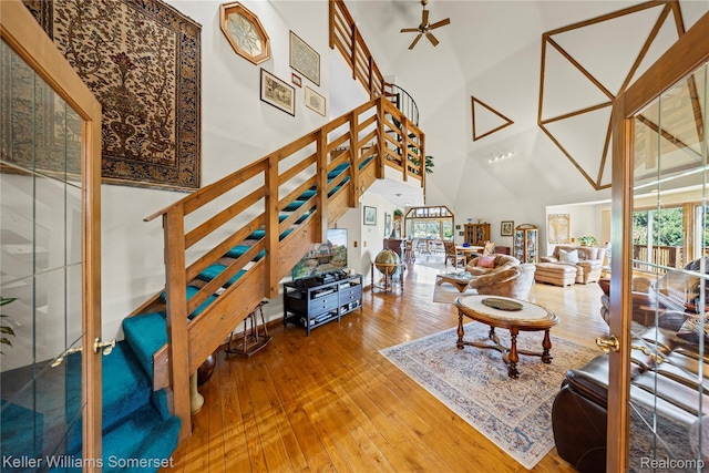 2637 E 7th Rd, Roscommon, MI 48653 - living room with stairs, hardwood / wood-style floors, a towering ceiling, and ceiling fan
