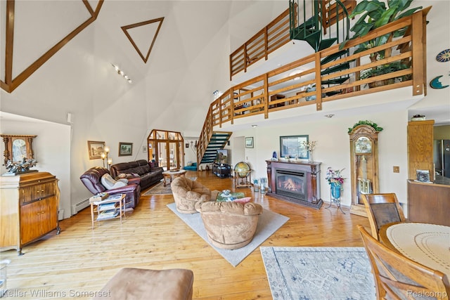 2637 E 7th Rd, Roscommon, MI 48653 - living area with a towering ceiling, wood finished floors, stairs, and a glass covered fireplace