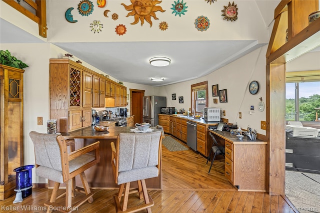 2637 E 7th Rd, Roscommon, MI 48653 - kitchen with appliances with stainless steel finishes, light wood-type flooring, a peninsula, and healthy amount of natural light