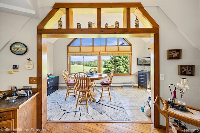 2637 E 7th Rd, Roscommon, MI 48653 - dining room featuring healthy amount of natural light, vaulted ceiling, hardwood / wood-style flooring, and baseboard heating