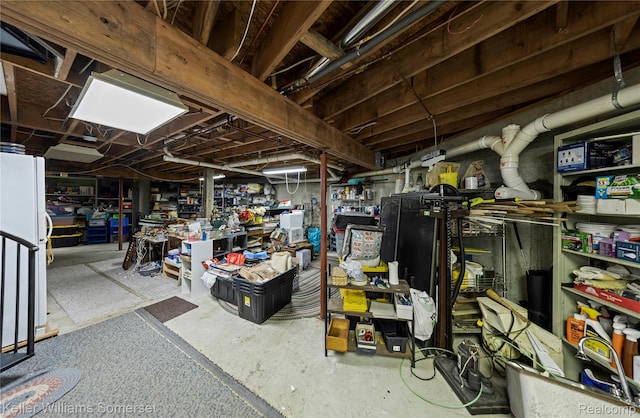 2637 E 7th Rd, Roscommon, MI 48653 - unfinished below grade area featuring a workshop area and freestanding refrigerator
