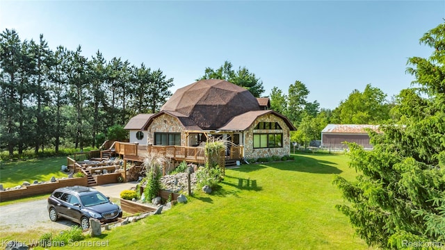 2637 E 7th Rd, Roscommon, MI 48653 - back of property with stone siding, a deck, and a yard