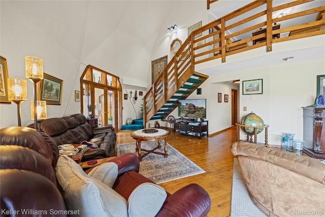2637 E 7th Rd, Roscommon, MI 48653 - living area featuring high vaulted ceiling, stairway, and wood-type flooring