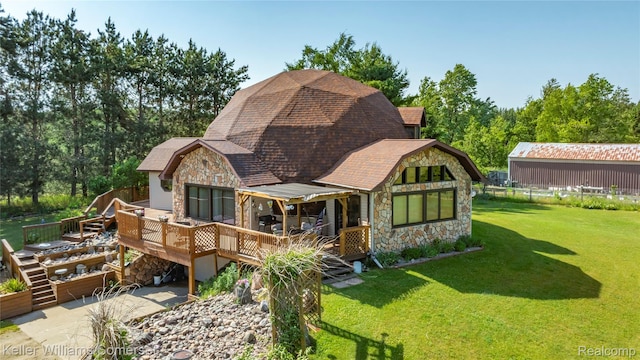 2637 E 7th Rd, Roscommon, MI 48653 - rear view of property featuring stone siding, a wooden deck, a lawn, a shingled roof, and a gambrel roof