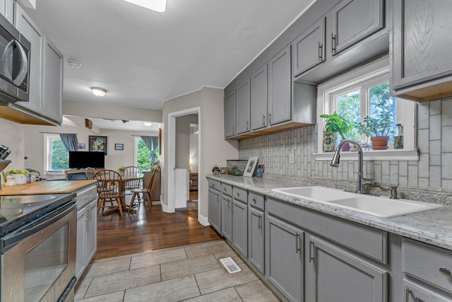 1026 Jennings Ave, Benton Harbor, MI 49022 - kitchen featuring gray cabinets, a sink, appliances with stainless steel finishes, and light countertops