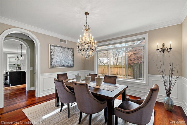 1419 Henrietta St, Birmingham, MI 48009 - dining room with wood finished floors, a chandelier, wainscoting, ornamental molding, and arched walkways