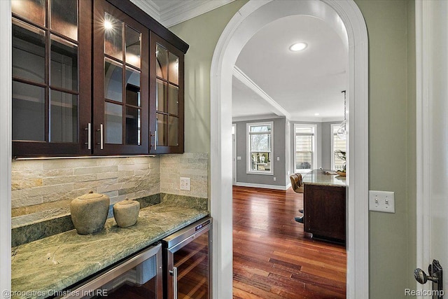 1419 Henrietta St, Birmingham, MI 48009 - indoor dry bar with wine cooler, crown molding, backsplash, dark wood-style flooring, and arched walkways