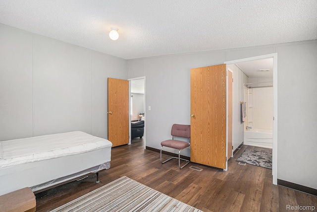 12342 N Mackinaw Hwy, Carp Lake, MI 49718 - bedroom with wood finished floors, connected bathroom, and a textured ceiling