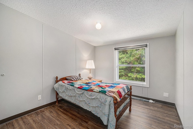 12342 N Mackinaw Hwy, Carp Lake, MI 49718 - bedroom featuring a textured ceiling and wood finished floors