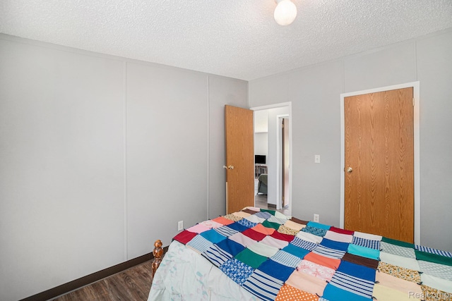 12342 N Mackinaw Hwy, Carp Lake, MI 49718 - bedroom with dark wood-type flooring and a textured ceiling