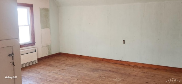 1701 Home Dr, Fairview, MI 48621 - empty room featuring radiator, light wood-style floors, healthy amount of natural light, and baseboards