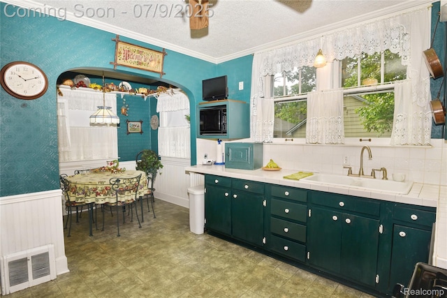 1719 Sycamore Ave, Royal Oak, MI 48073 - kitchen featuring wallpapered walls, a wainscoted wall, green cabinets, ornamental molding, and light flooring