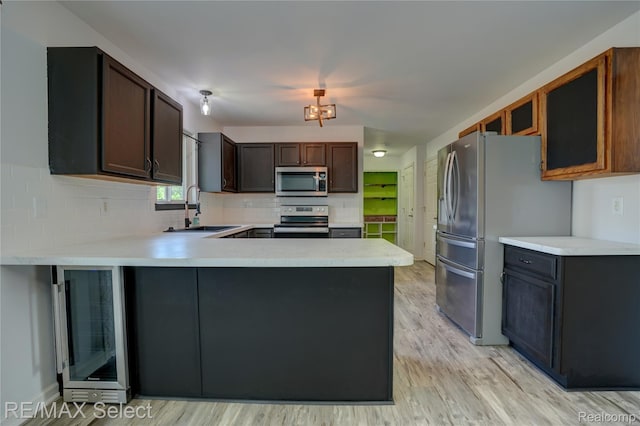 11468 Grand Oaks Dr, Clio, MI 48420 - kitchen featuring stainless steel appliances, beverage cooler, a peninsula, and light countertops