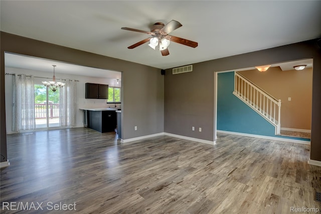 11468 Grand Oaks Dr, Clio, MI 48420 - unfurnished living room with ceiling fan, a chandelier, wood finished floors, stairs, and baseboards