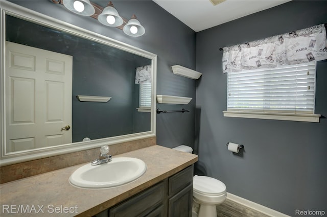 11468 Grand Oaks Dr, Clio, MI 48420 - bathroom with plenty of natural light, vanity, toilet, and baseboards