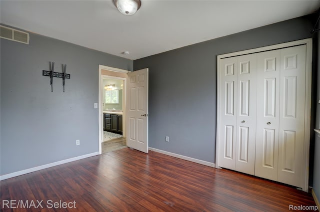 11468 Grand Oaks Dr, Clio, MI 48420 - unfurnished bedroom featuring dark wood finished floors, a closet, and baseboards