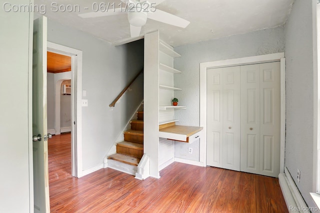 22521 Hoffman St, Saint Clair Shores, MI 48082 - staircase with wood finished floors, a ceiling fan, and a baseboard heating unit
