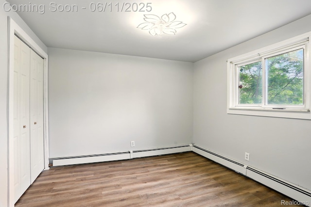 22521 Hoffman St, Saint Clair Shores, MI 48082 - unfurnished bedroom with a closet, wood finished floors, and a baseboard radiator