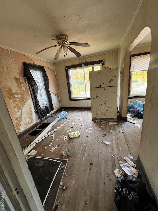 1039 Markham St, Flint, MI 48507 - unfurnished living room with crown molding, hardwood / wood-style floors, arched walkways, a ceiling fan, and a textured ceiling