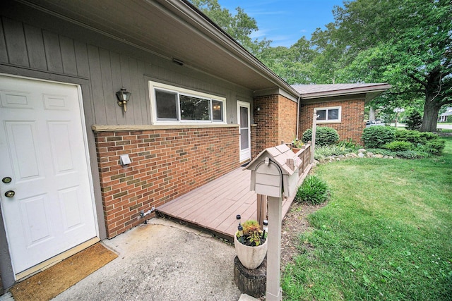 55 E Lewis Ave, Milan, MI 48160 - doorway to property with brick siding, a yard, and a wooden deck