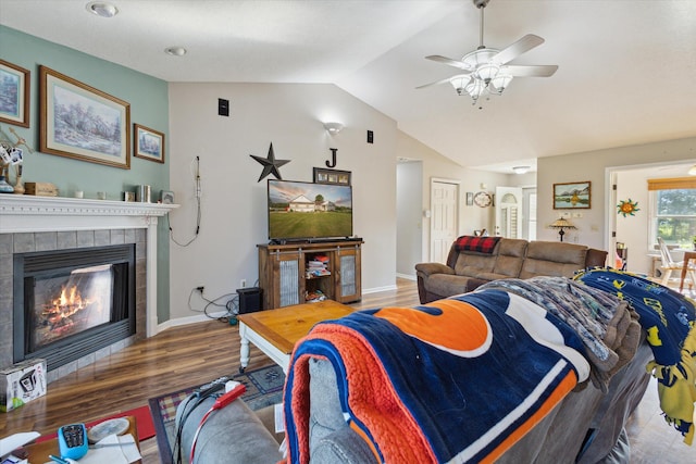 8078 S Royston Rd, Eaton Rapids, MI 48827 - living room with wood finished floors, lofted ceiling, a tiled fireplace, and a ceiling fan