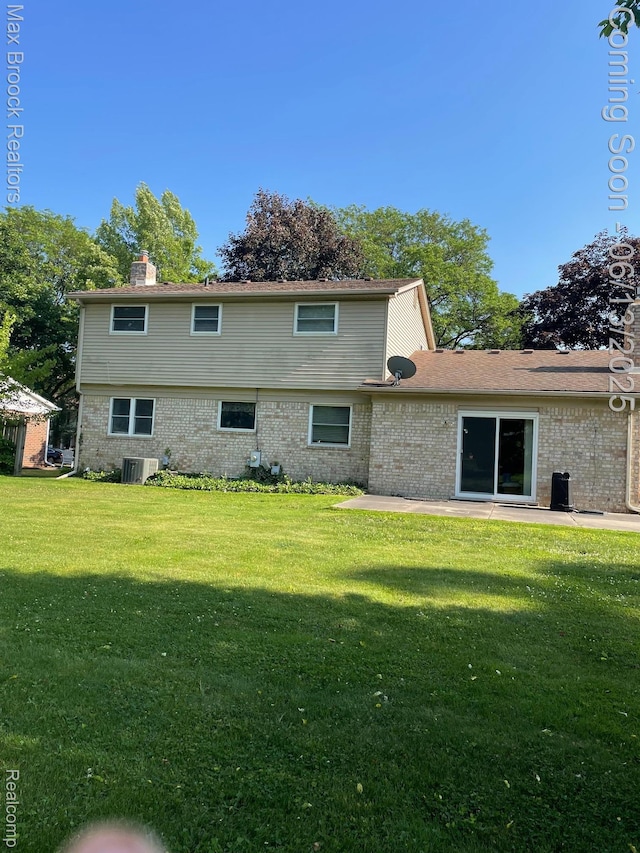 2669 Willard Dr, Troy, MI 48085 - rear view of house with brick siding, a lawn, a patio, and a chimney