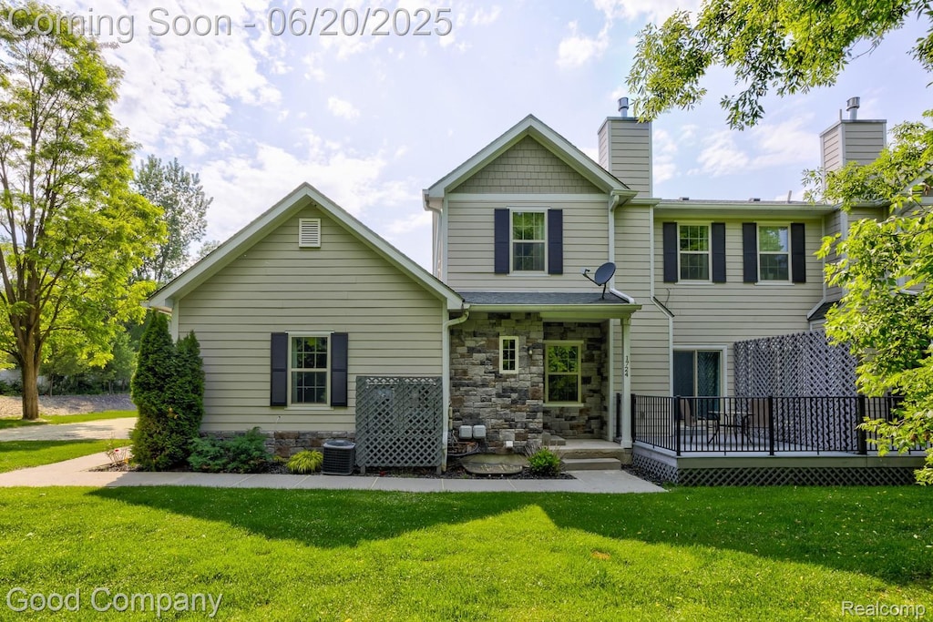 1724 Barrington Ct, Lake Orion, MI 48360 - view of front of house featuring a front lawn, a chimney, and stone siding