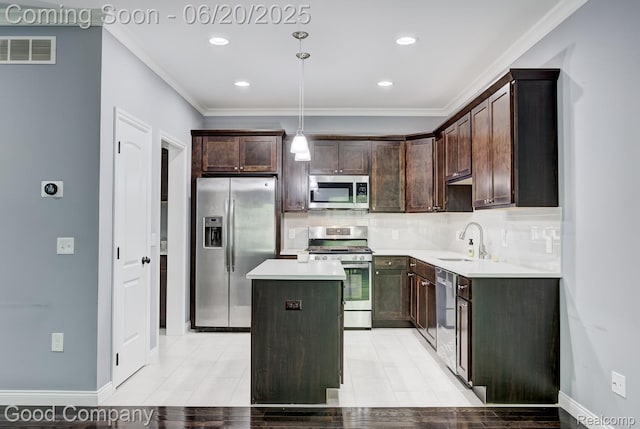 1724 Barrington Ct, Lake Orion, MI 48360 - kitchen featuring appliances with stainless steel finishes, dark brown cabinets, a center island, decorative backsplash, and crown molding